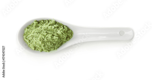 Spoon with natural wheat grass powder isolated on white