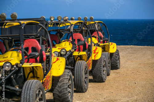 yellow beach buggies without driver in background the blue sea
