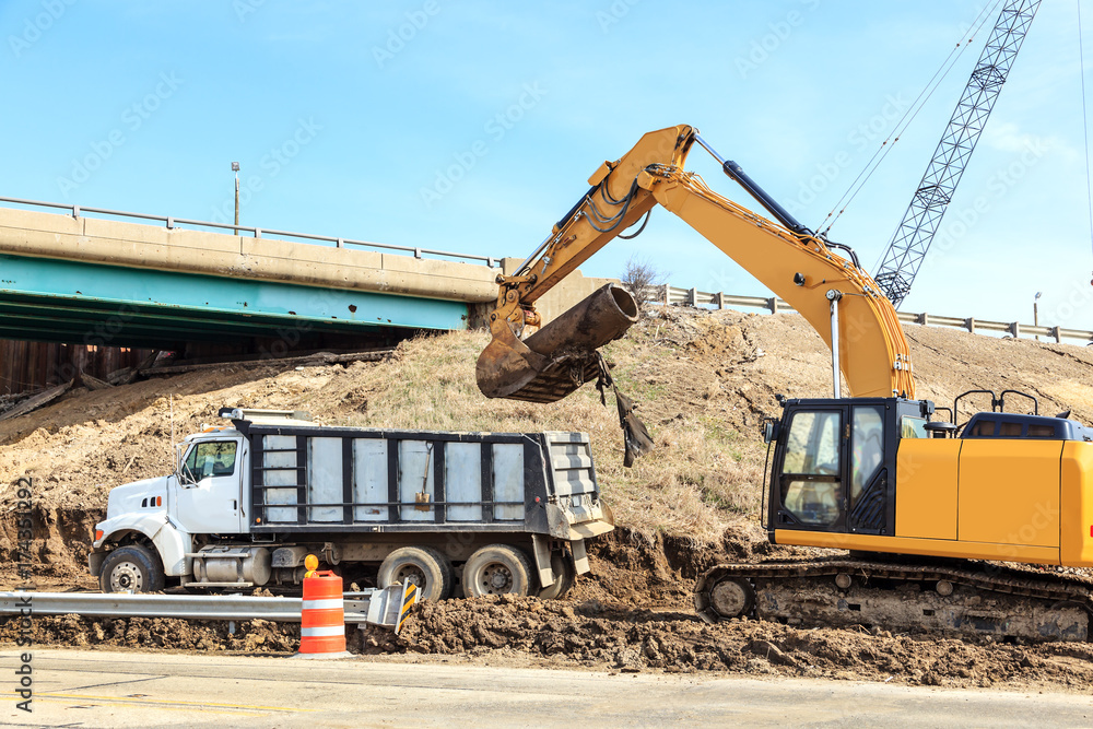 Backhoe and dump truck excavating on a job site Backhoe and dump truck excavating on a job site
