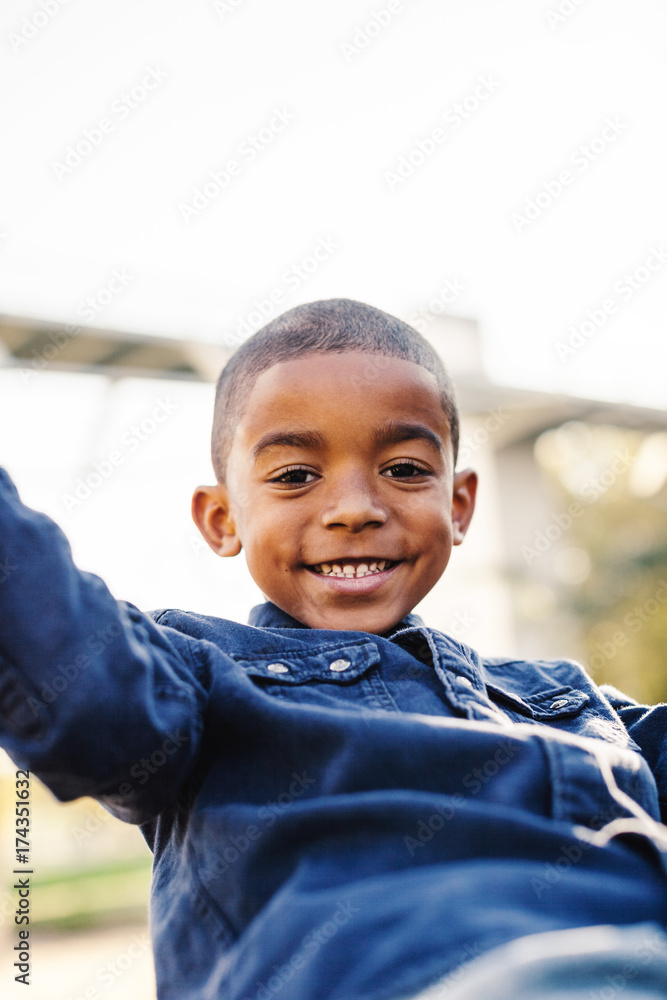 Smiling black boy playing on a playground swing. Smiling black boy playing on a playground swing.