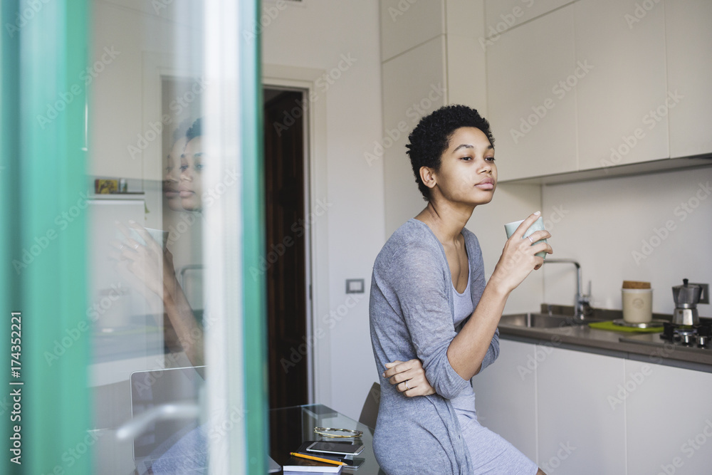 Young attractive African woman relaxing at home with a cup of coffee Young attractive African woman relaxing at home with a cup of coffee