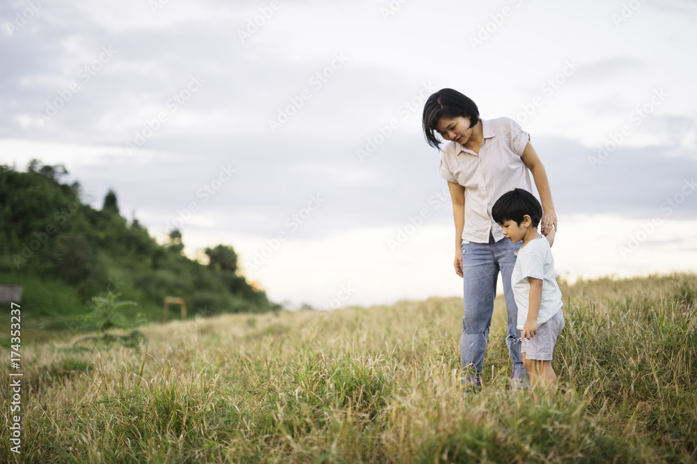 Mother and son exploring the grass field Mother and son exploring the grass field