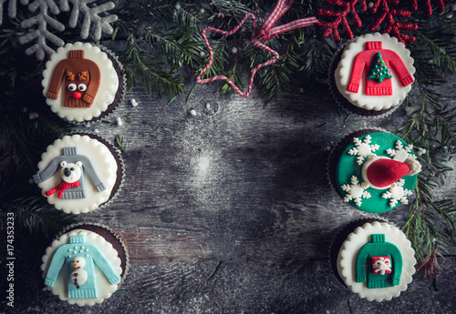 Christmas decorative cupcakes on wooden background with blank space in the middle