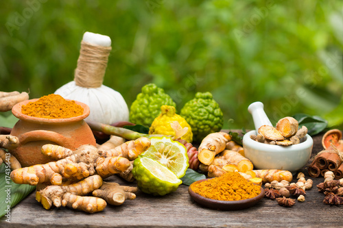 Turmeric powder,Turmeric in Mortar Grinder drugs and ingredient herbs on wooden background photo