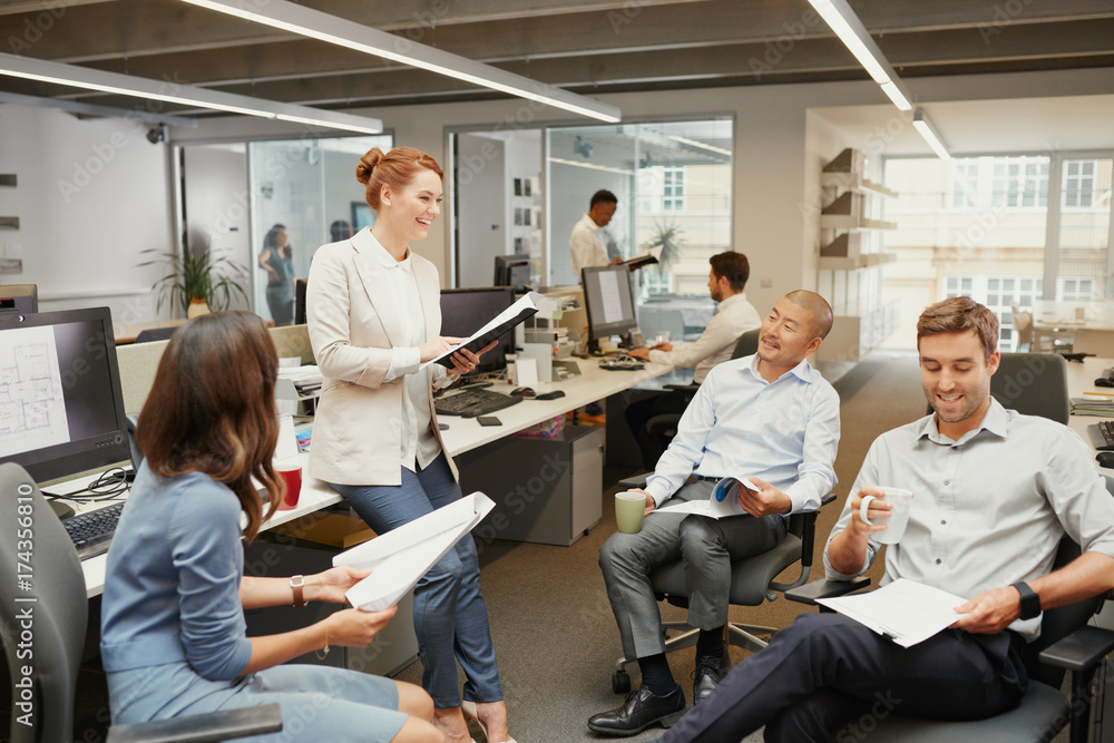 Casual team meeting in open office discussing business Casual team meeting in open office discussing business