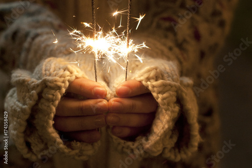 Close up shot of hands holding sparklers photo