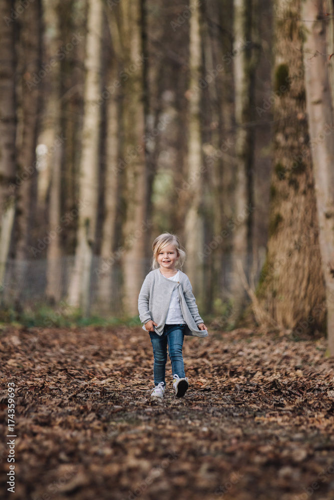 trendy cute little girl strolling through foliage covered forest trendy cute little girl strolling through foliage covered forest