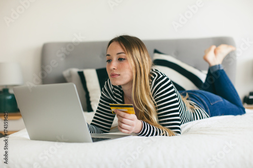 Woman shopping online with her credit card from home. photo