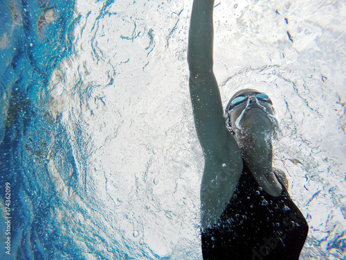 Underwater view of woman swimming photo