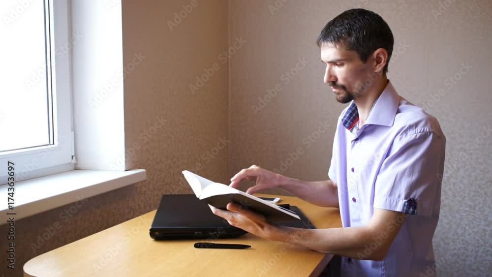 Young serious guy with diary in his hands Young serious guy with diary in his hands