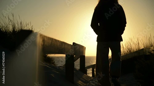 Woman walks alone by the sea shore at sunset - sequence with several clips