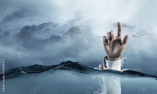 Hand of person drowning in water