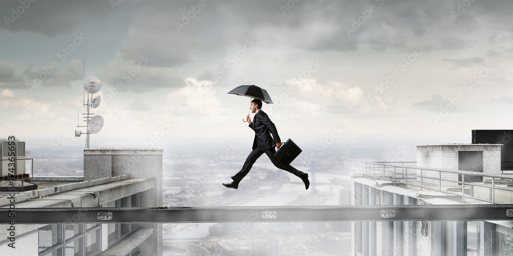 Fearless businessman overcoming difficulty. Mixed media Fearless businessman overcoming difficulty. Mixed media