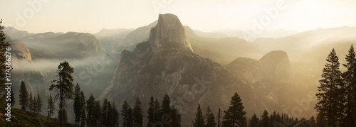Magical morning sunshine and fog rises over Glacier Point at Yosemite National Park photo