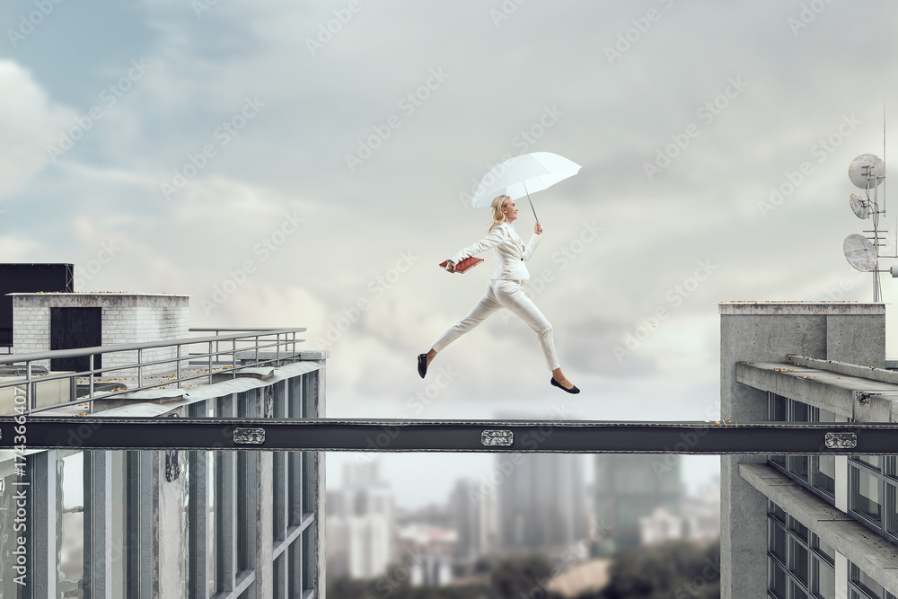 Fearless businesswoman overcoming difficulty. Mixed media Fearless businesswoman overcoming difficulty. Mixed media