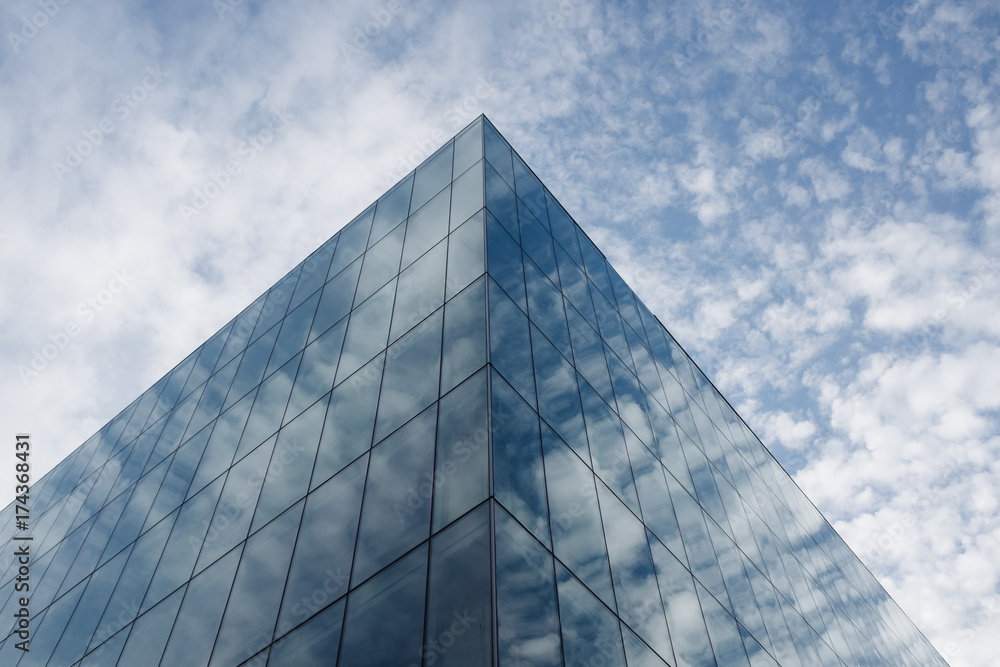 Low angle view of modern office building and sky, clouds reflecting in windows Low angle view of modern office building and sky, clouds reflecting in windows