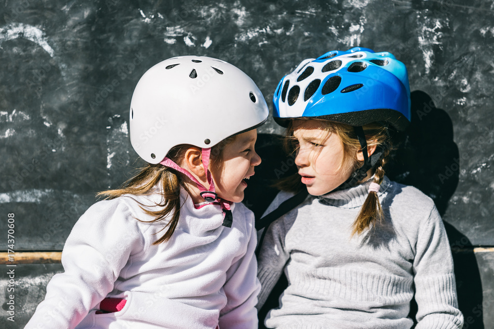 Two Sisters Having a Break During a Rollerblading Exercise Two Sisters Having a Break During a Rollerblading Exercise