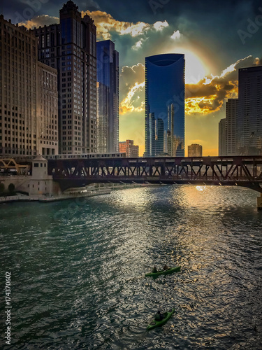 Sunset over Chicago River with recreational kayaks floating through the Loop.