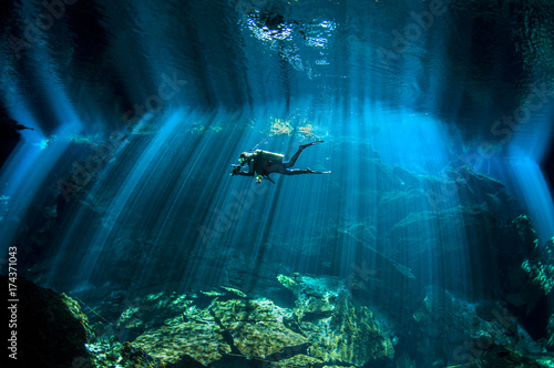 Man diving in Chac Mool Cenote, Mexico photo