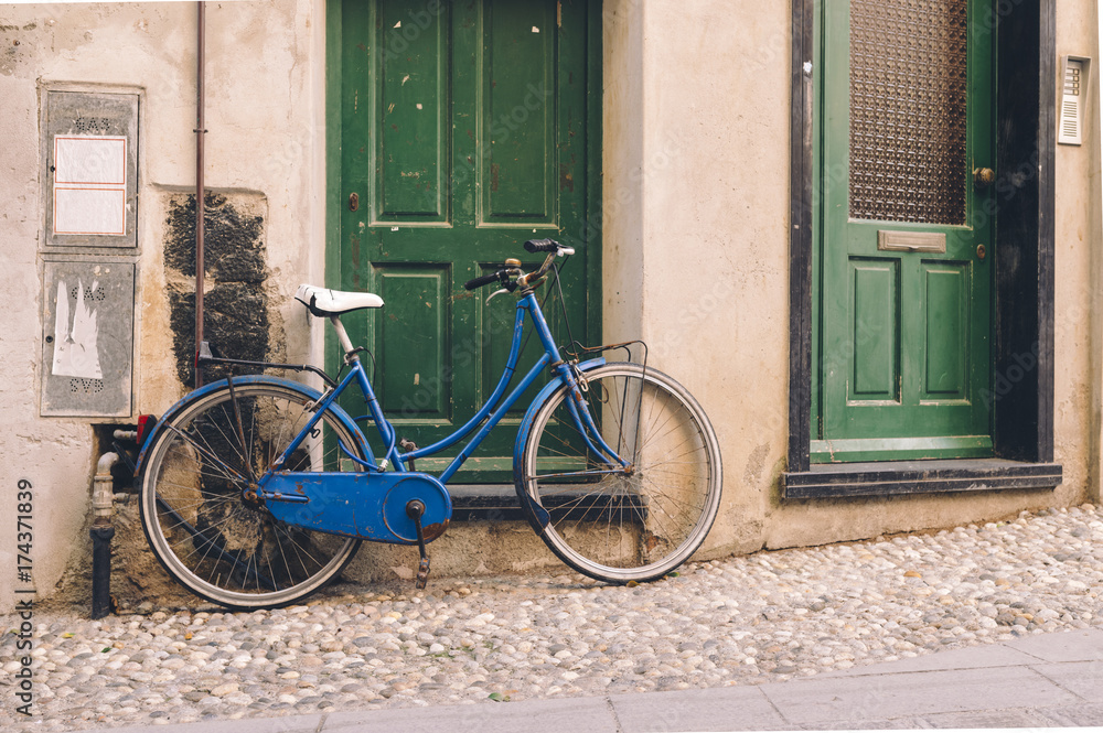 View on blue bicycle parked near green doors View on blue bicycle parked near green doors
