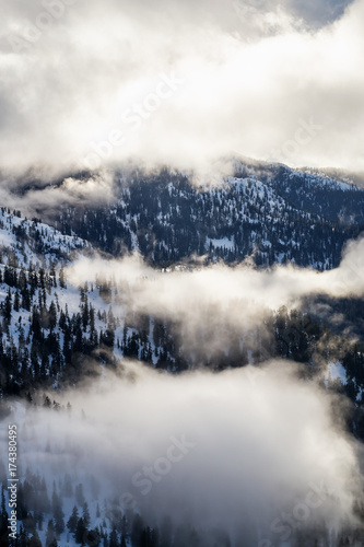 Aerial landscape view of the snow and cloud covered mountain range North of Vancouver, British Columbia, Canada.