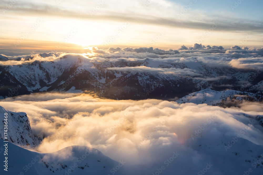 Beautiful Aerial Landscape View of the Mountain Range covered in Clouds during Sunset. Picture taken North of Vancouver, British Columbia, Canada.