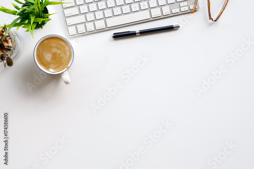 Stylish minimalistic workplace with keyboard, notebook, office plant, notebook, glasses in flat lay style. White background. Top view.