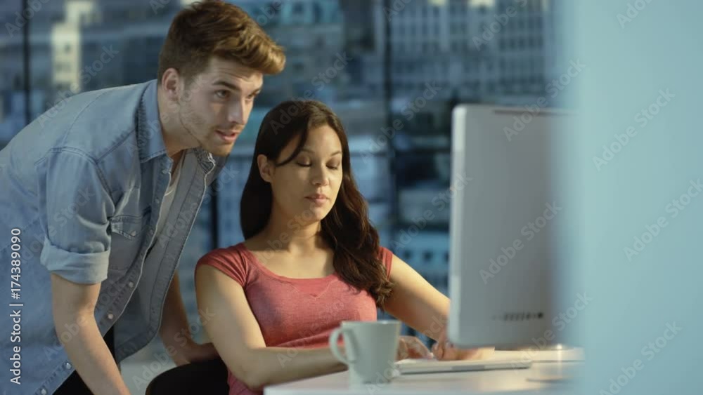 Young couple chatting & using computer together in city apartment Young couple chatting & using computer together in city apartment