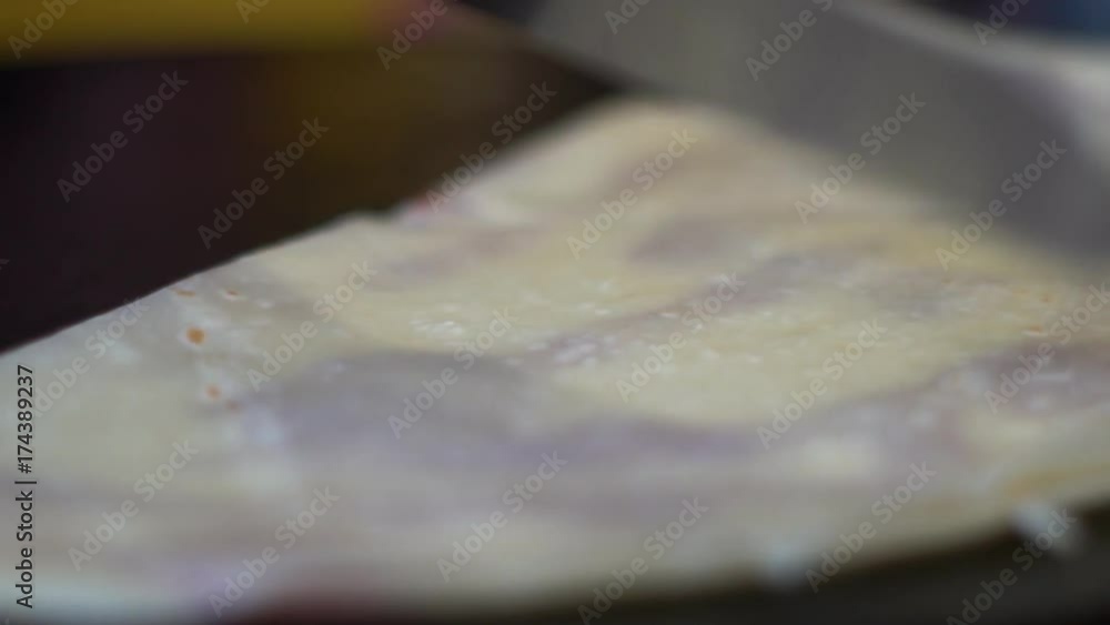 Sweet, delicious pancake. The cook wraps the finished pancake with jam. Sweet, delicious pancake. The cook wraps the finished pancake with jam.