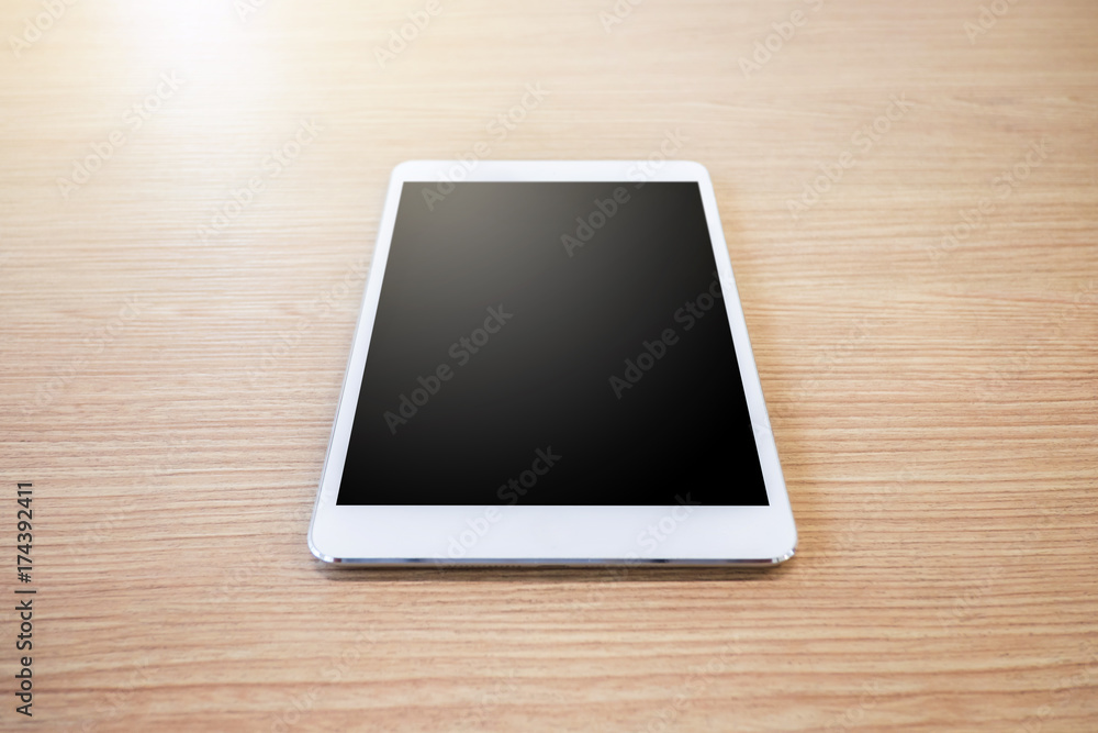 White digital tablet on wooden table background White digital tablet on wooden table background