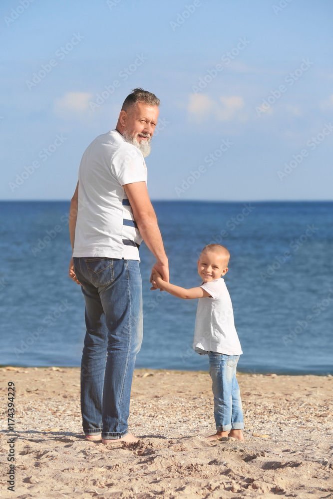 Cute boy with grandfather on sea beach Cute boy with grandfather on sea beach