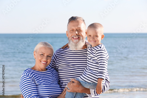 Cute boy with grandparents on sea beach © Africa Studio