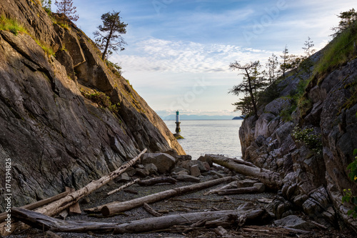 Landscape view on the logs laying on the rocky shore between the cliffs. Picture taken in Whytecliff Park, West Vancouver, British Columbia, Canada, on a beautiful sunny day. © edb3_16