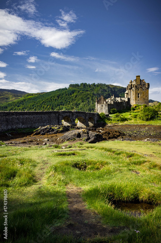 Gorgeous sun kissed vertical view of Eilean Donan Castle on a bright summer's day.
