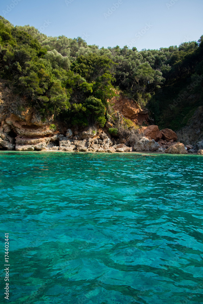  turquoise green transparent water on a background of bright limestone rocks in a bright summer day