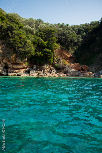  turquoise green transparent water on a background of bright limestone rocks in a bright summer day