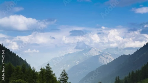Timelapse: Blue sky and afternoon clouds shift to evening light over the town of Col de la Forclaz in the Alps along the Tour du Mont Blanc.