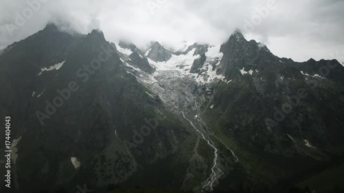 Timelapse: Clouds and storm move in to the mountains of the Alps across the valley from the Walter Bonatti Hut and refugio in Italy. Tour du Mont Blanc. photo