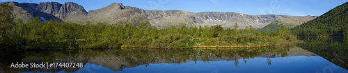 panorama with the mountains of the Khibiny  sky reflected in the lake Small Vudyavr. Kola Peninsula  Russia.