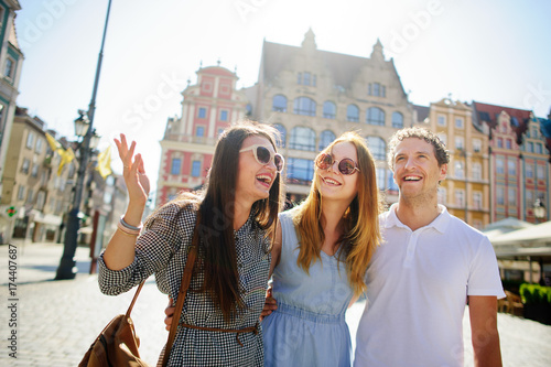 Foto Three young people stand on the square of the ancient city.