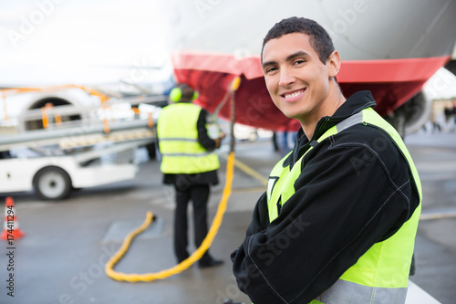 Confident Male Worker Smiling While Airplane Being Charged At Ru