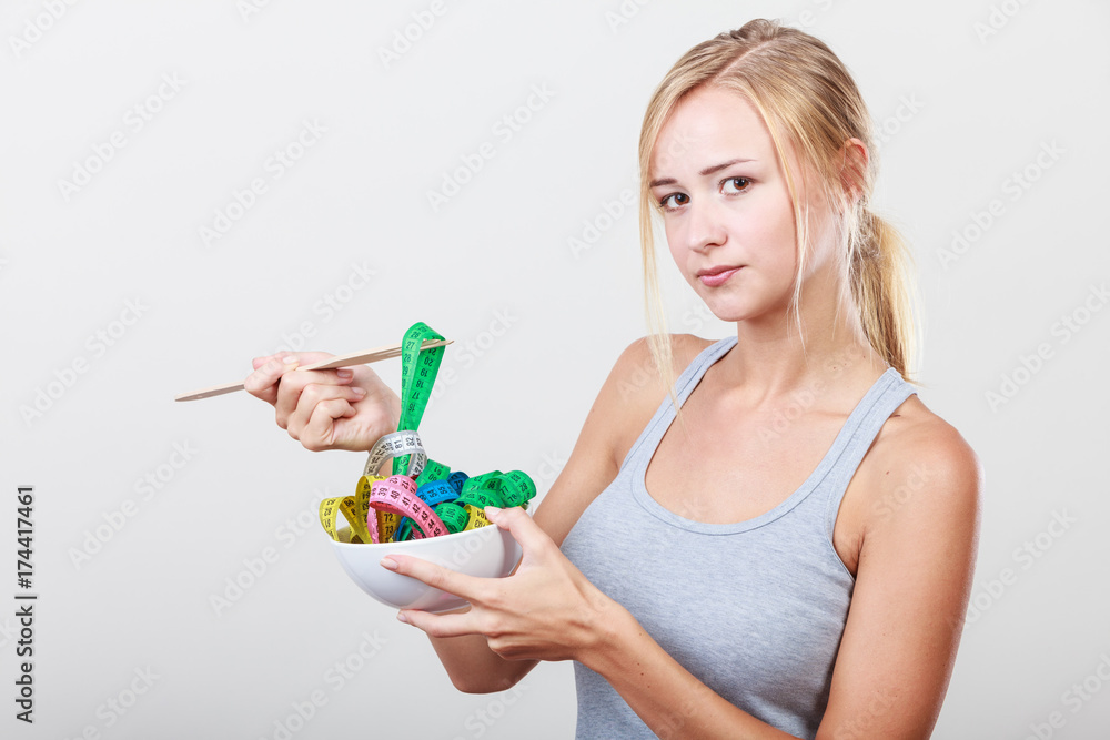Diet. Girl with colorful measuring tapes in bowl Diet. Girl with colorful measuring tapes in bowl