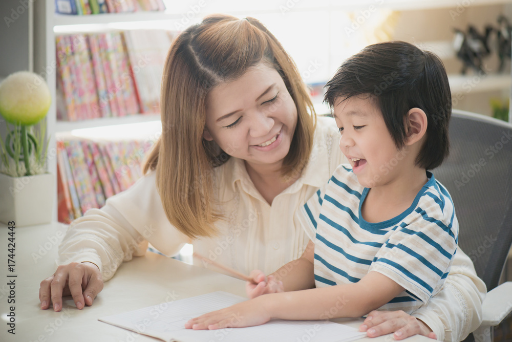 Asian mother helping her son doing homework Asian mother helping her son doing homework