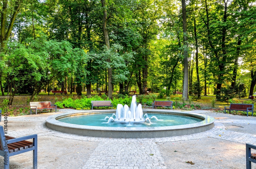 Nice fountain in the urban park. Green park in the city of Chrzanow, Poland.