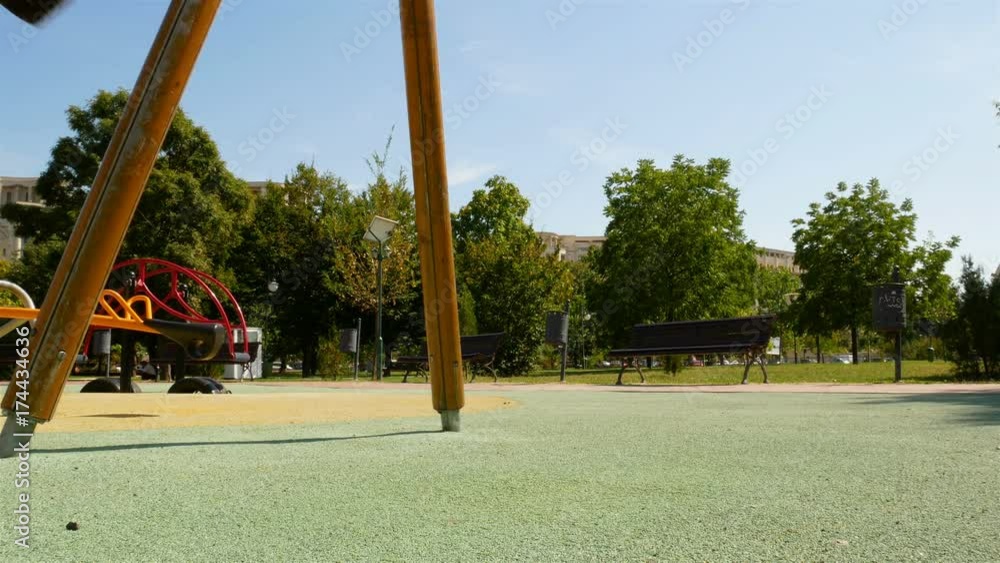 empty swing with chains swaying at playground for child, moved, on green meadow background, 4k video empty swing with chains swaying at playground for child, moved, on green meadow background, 4k video