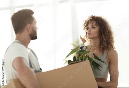 Husband and wife bring boxes with things to a new apartment