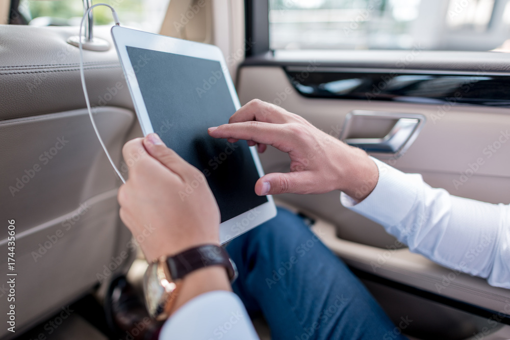 man with digital tablet in car