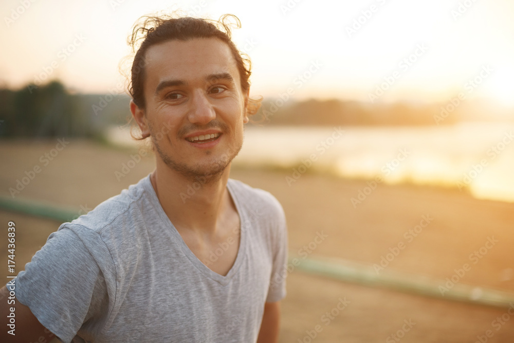 Handsome man smiling in the park after workout Handsome man smiling in the park after workout