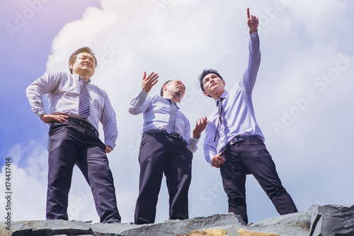 group of businessman disscuss and set pointing to goal concept stand over the cliff. low angle view. photo