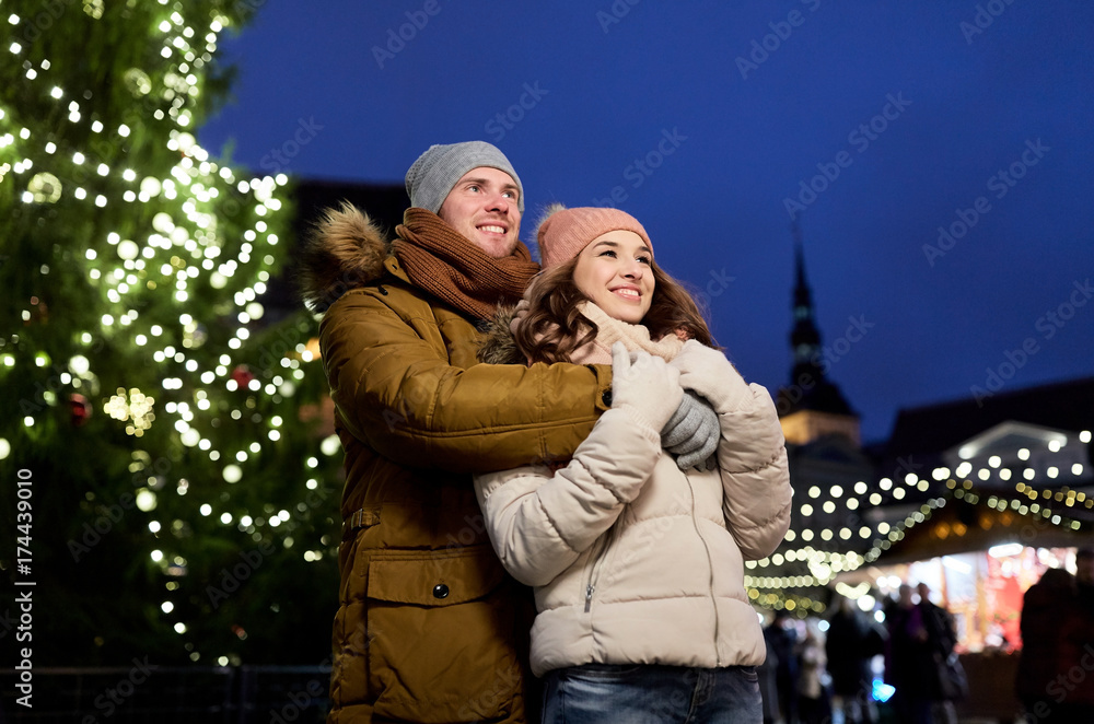 happy couple hugging at christmas tree